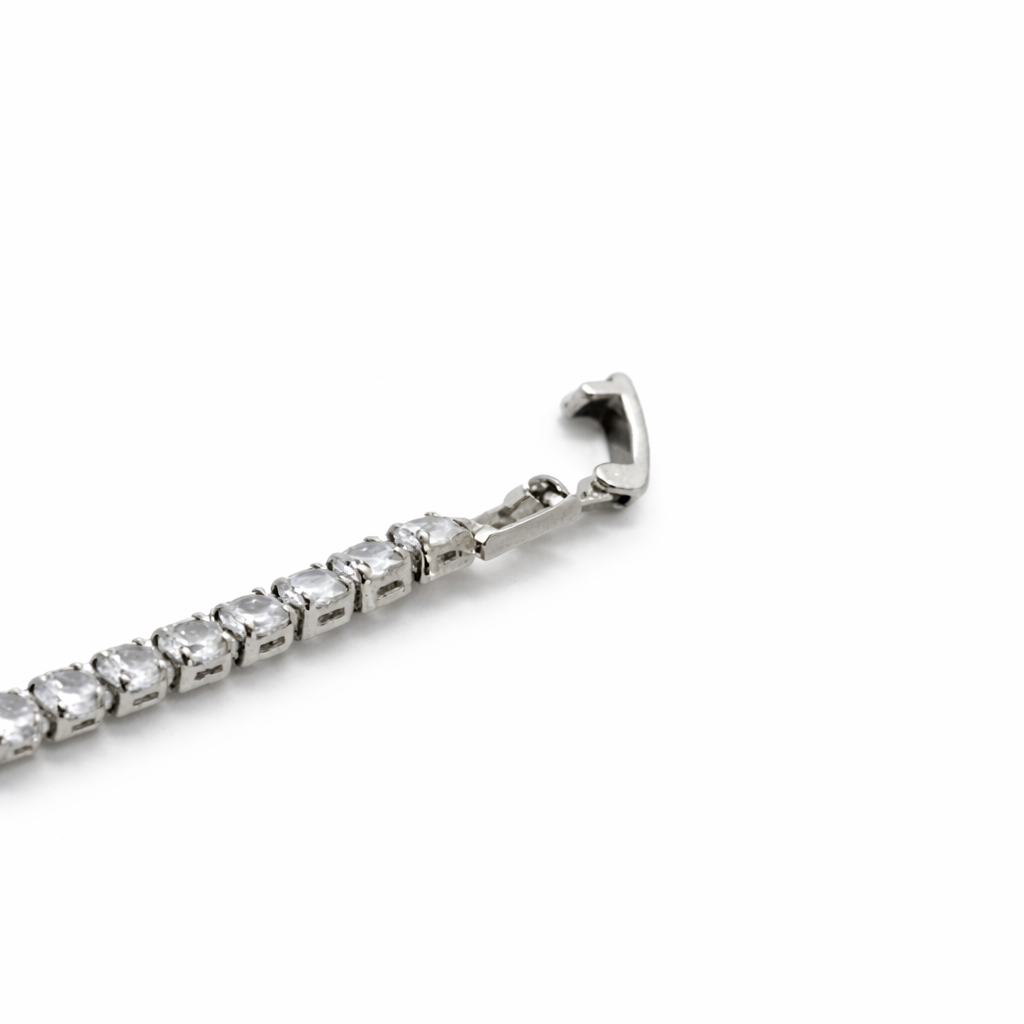 Silver bracelet with clear gemstones on a white background