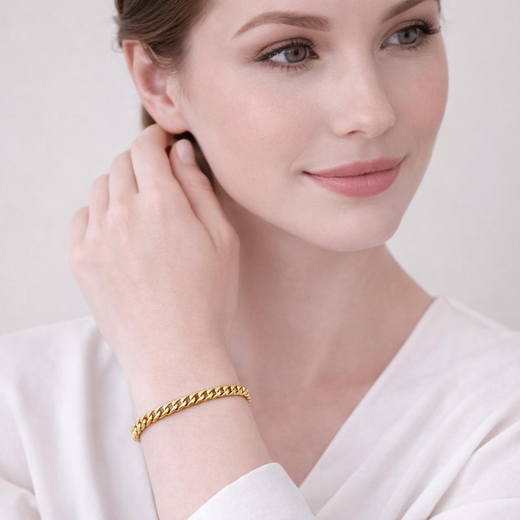 Woman wearing a gold bracelet on a plain background