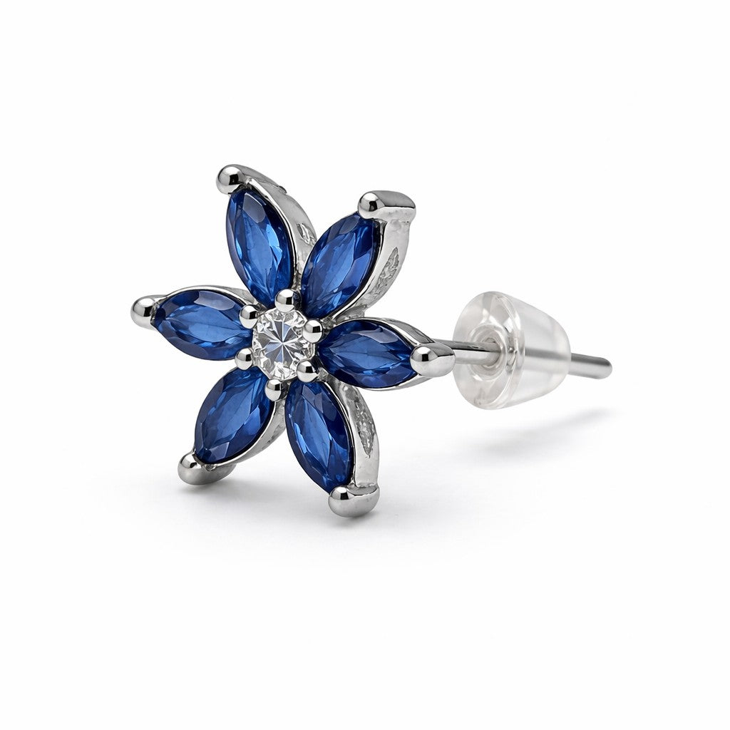 Flower-shaped earring with blue gemstones and a clear center on a white background