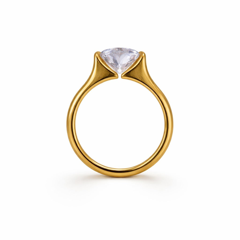 Gold-tone ring with a clear gemstone on a white background