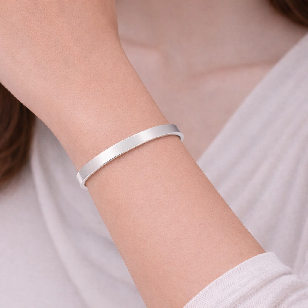 Silver-tone bangles with minimal cuff design styled on wrist