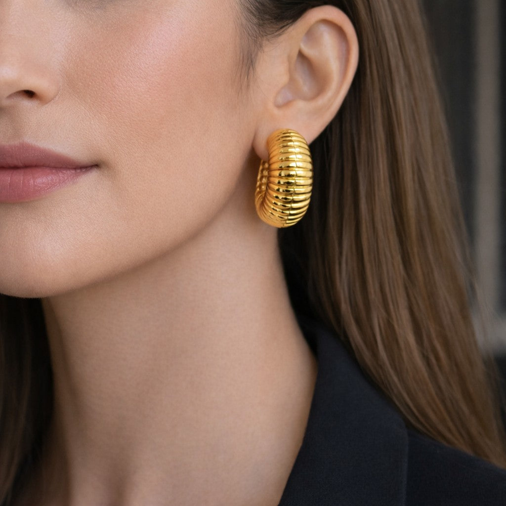 Close-up of chunky hoop earrings for women with textured gold-tone finish