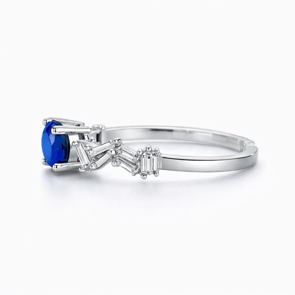 Silver ring with a blue gemstone and smaller diamonds on a white background
