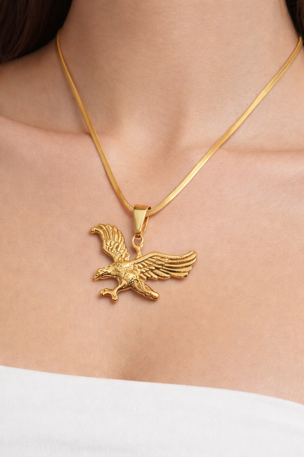 Close-up of pendant necklace with eagle design on chain