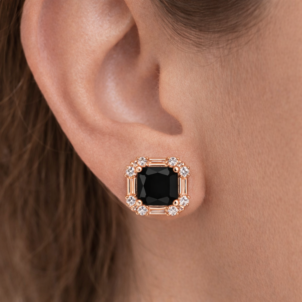 Rose gold earring with a black gemstone worn on an ear
