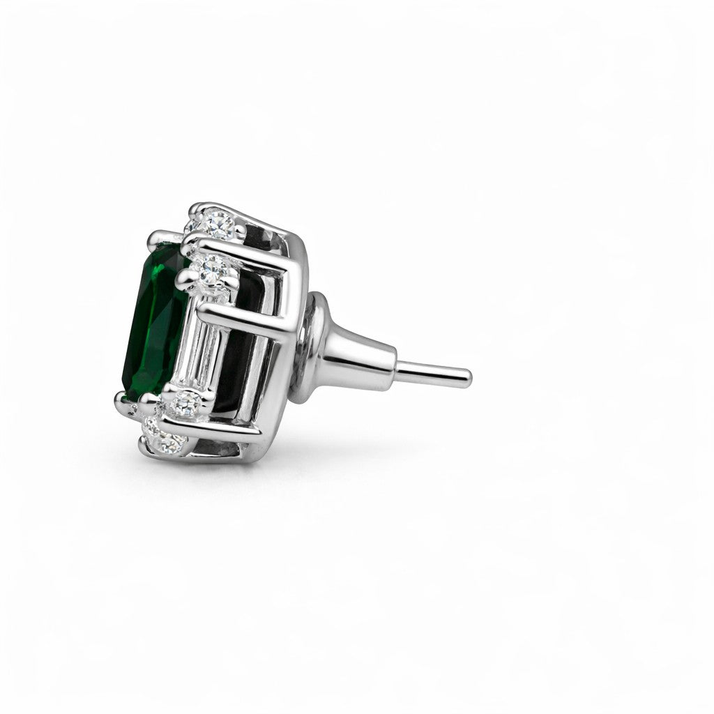 Silver earring with a green gemstone on a white background