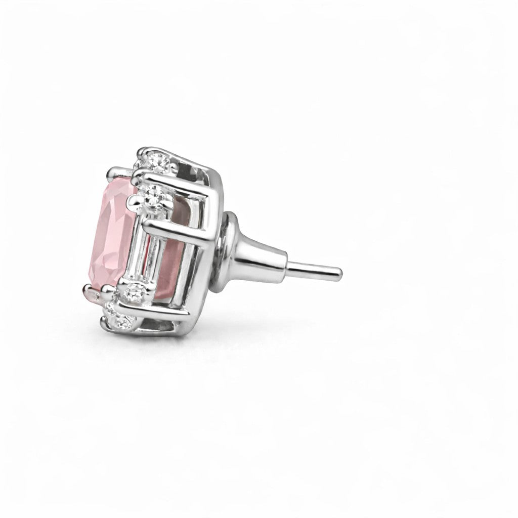 Silver earring with pink gemstone on a white background