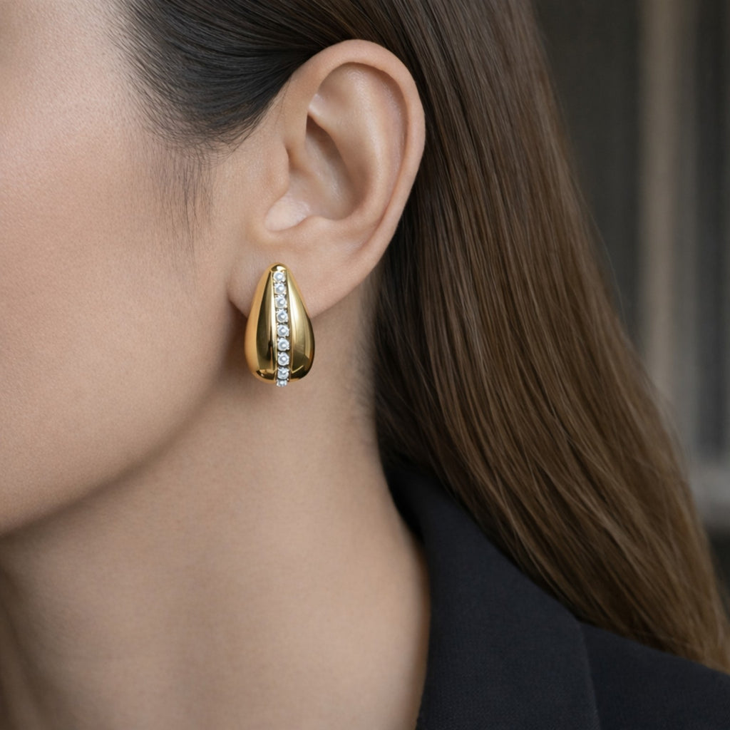 Gold earring worn by a women with a blurred background