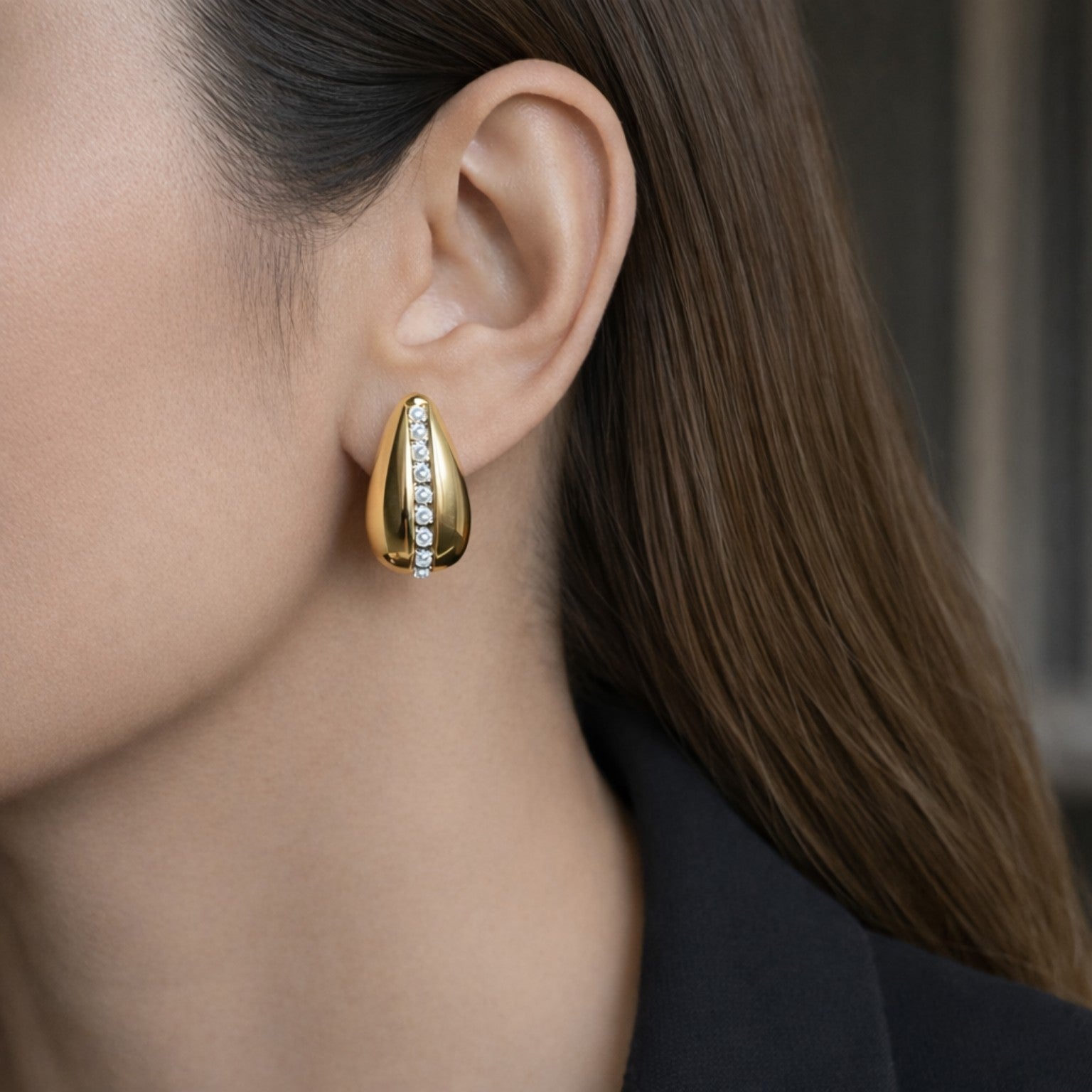 Gold earring worn by a women with a blurred background
