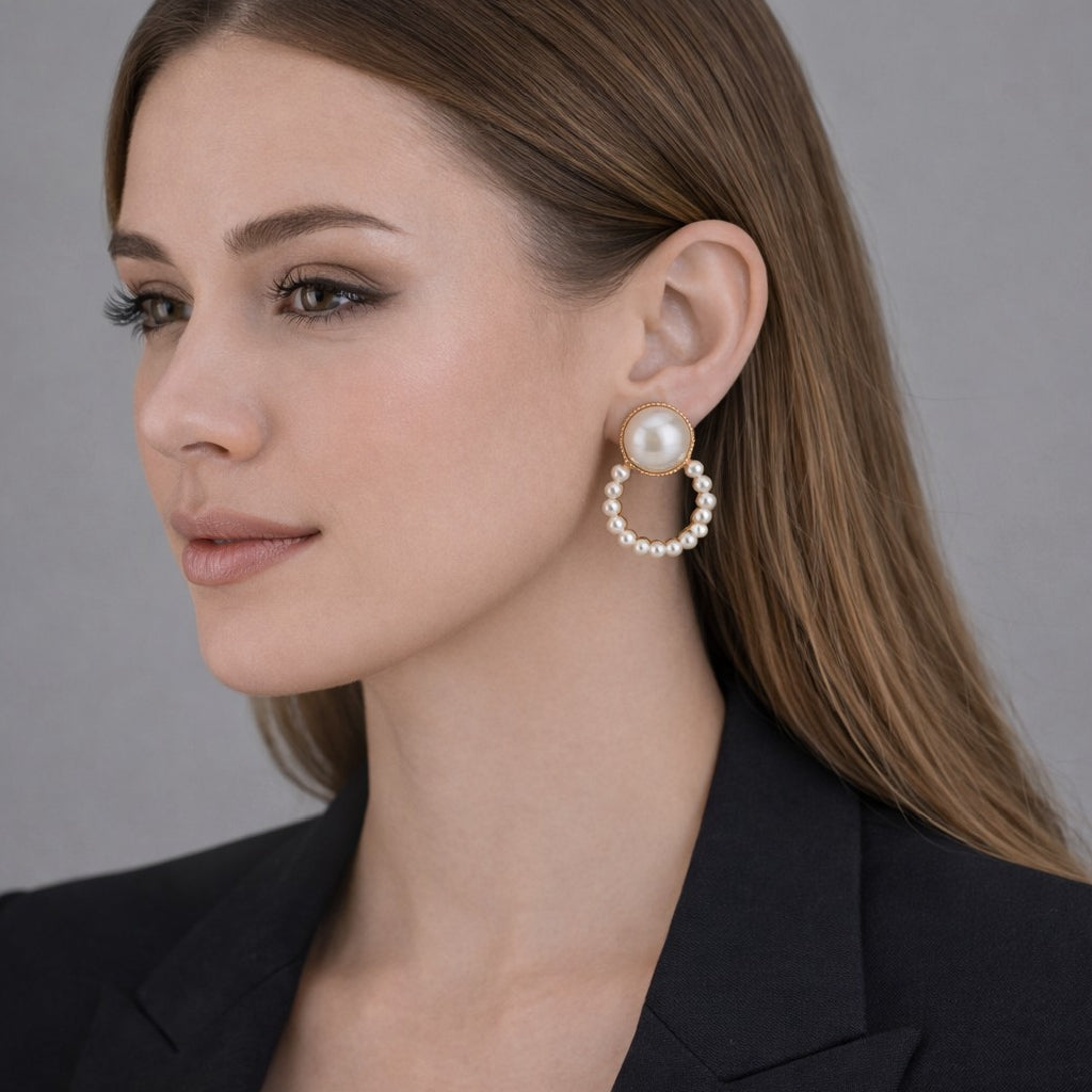 Woman wearing pearl hoop earrings against a neutral background