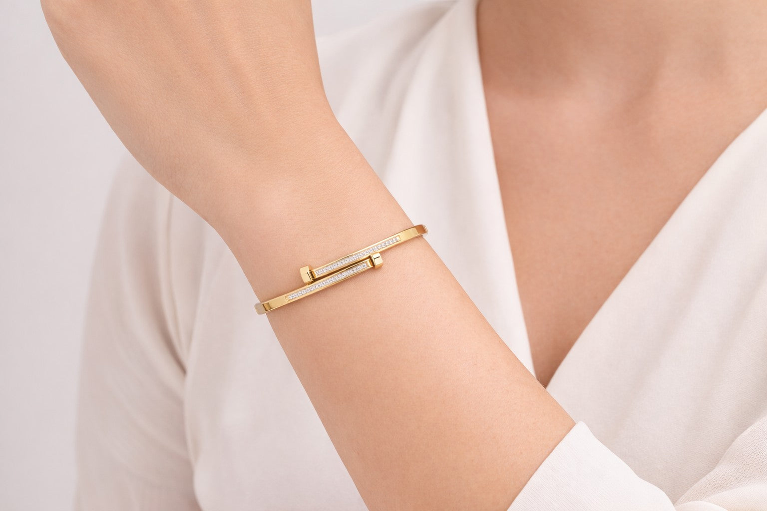 Poise Bangle worn as nail bangle with polished gold-tone structure on wrist