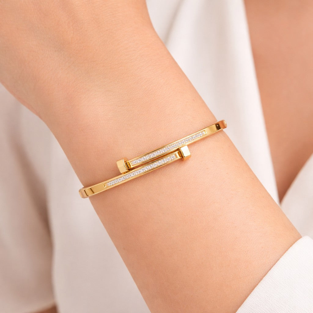 Close-up of stone bangle styled on wrist in a gold-tone finish