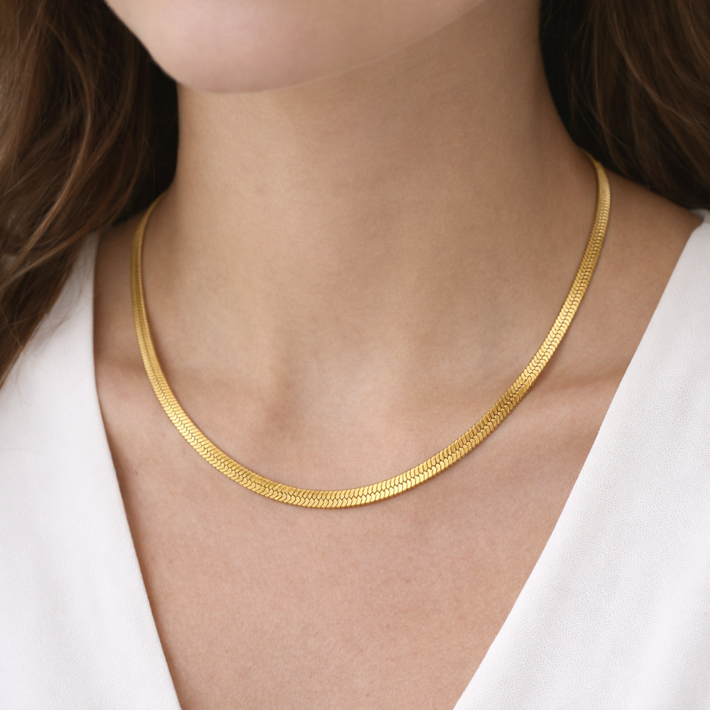 Close-up of necklaces for women styled on neckline with gold-tone snake chain
