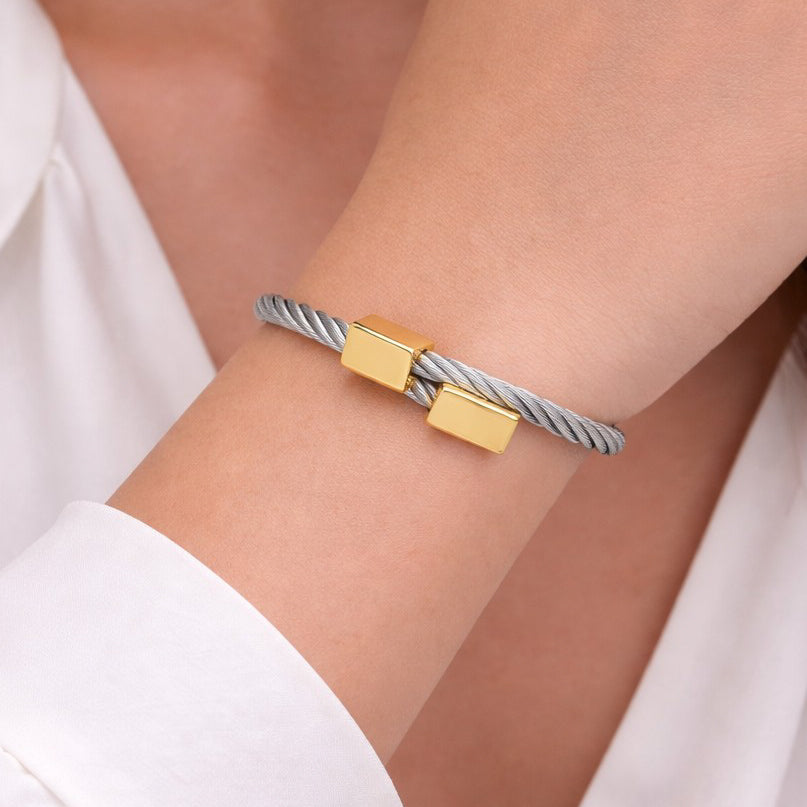 Close-up of bangles with silver and gold-tone mixed-metal design on wrist