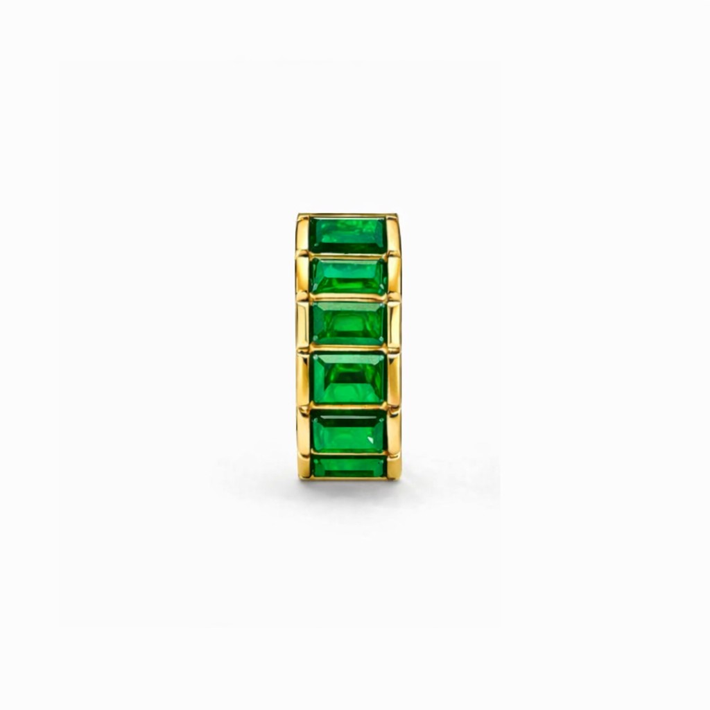 Gold ring with green gemstones on a white background