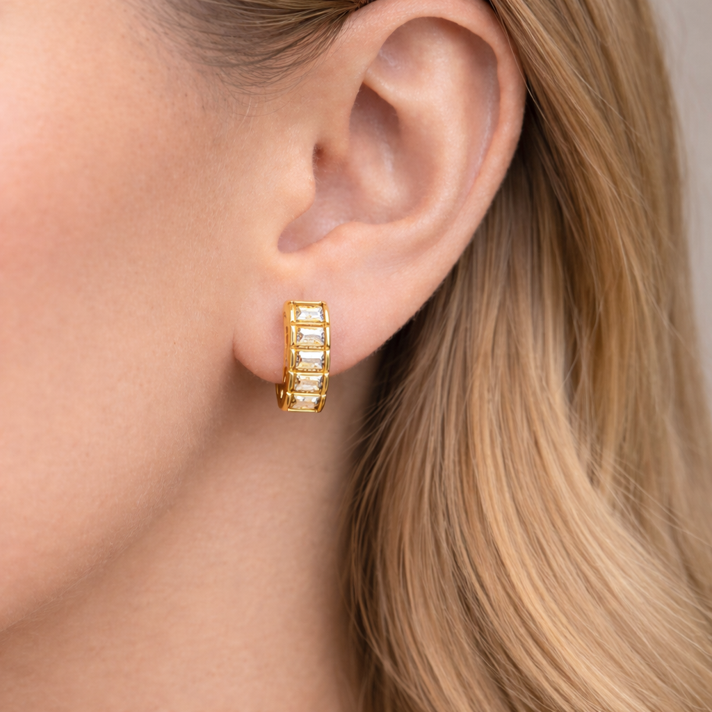 Gold hoop earrings worn by a person with blonde hair.