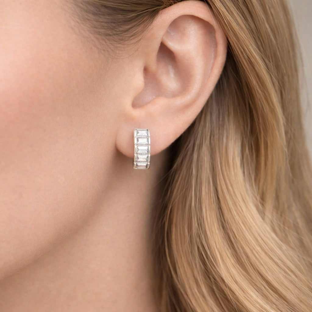 Silver hoop earring worn by a person with blonde hair.