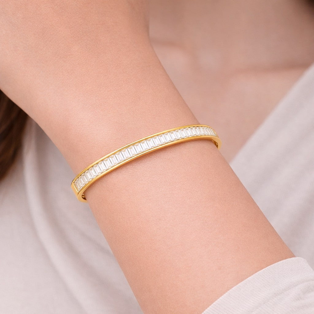 Close-up of stone bangle styled on wrist in a gold-tone finish