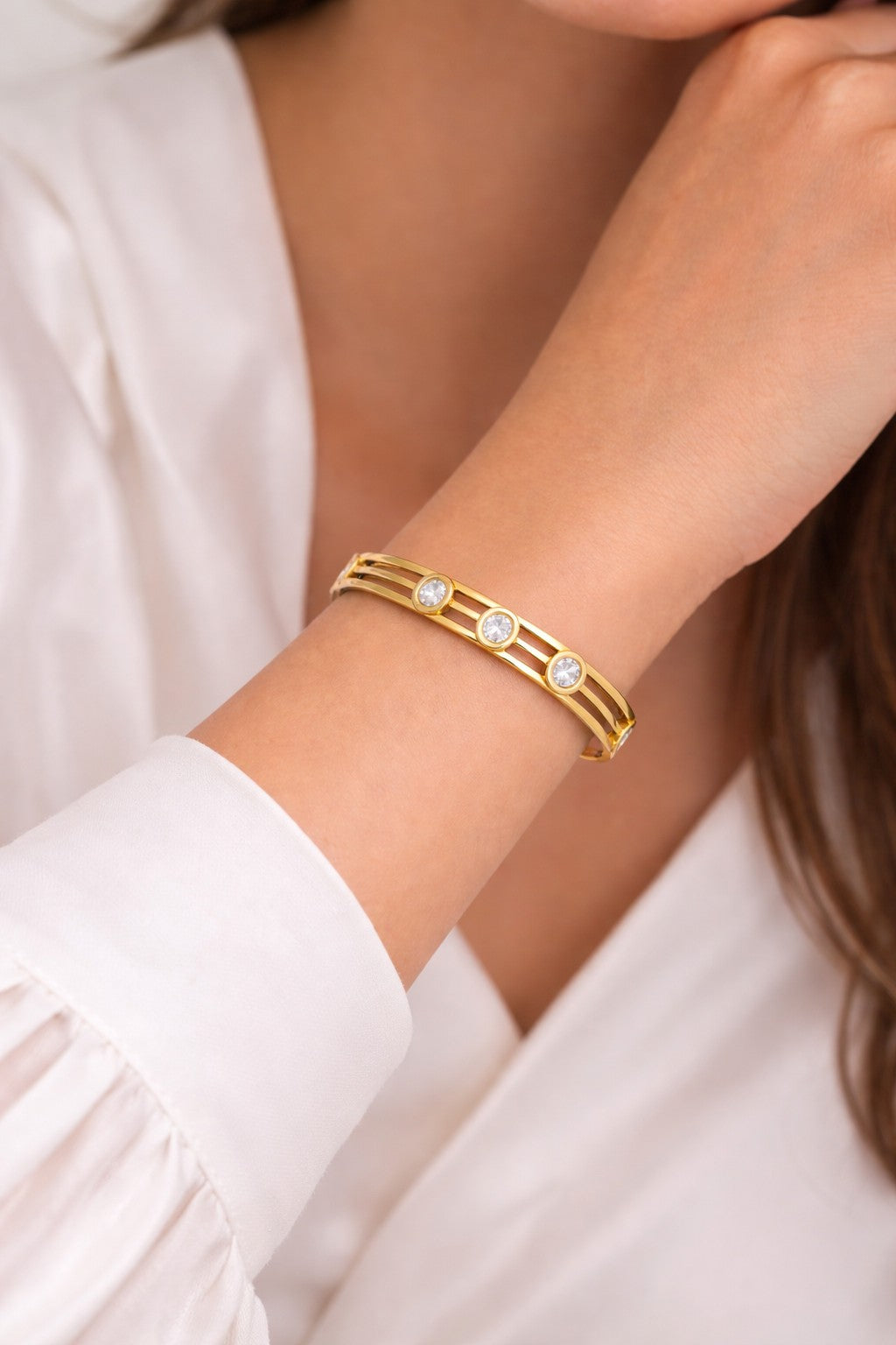 Gold tone bracelet with clear stones on a women wrist
