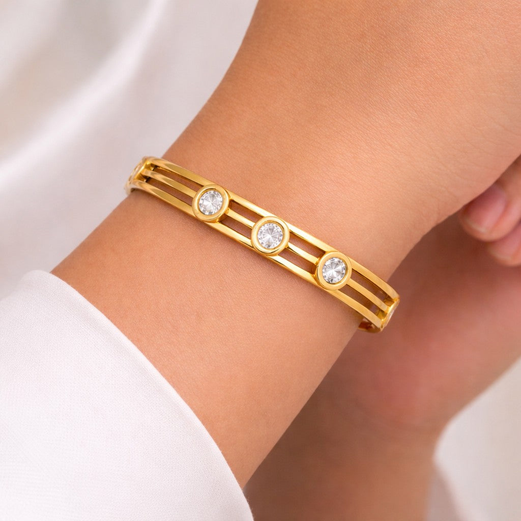 Close-up of bangles styled on wrist with three stone detail