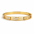 Front view of artificial bangles with gold-tone cuff design and three stone accents